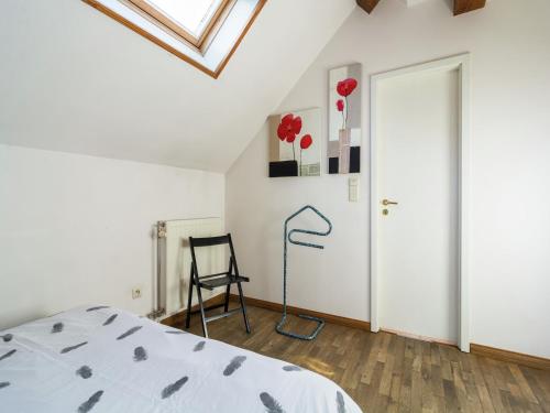 a bedroom with a bed and a chair next to a door at Peaceful Fontenelle Farmhouse in Walcourt