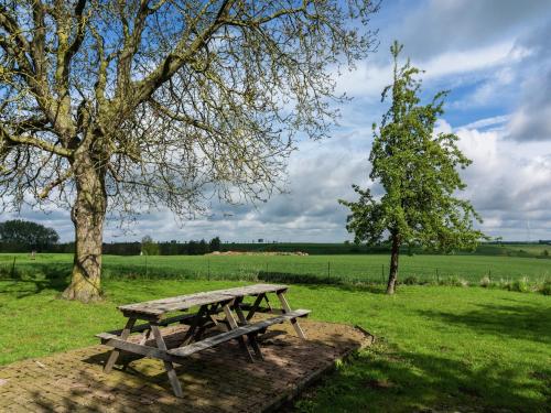 a picnic table in a field next to a tree at Peaceful Fontenelle Farmhouse in Walcourt