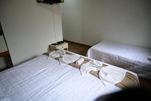 a bedroom with two beds with towels on them at Tangaras da Serra in Macaé