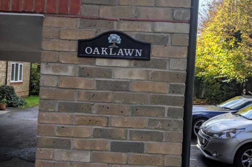 a sign on the side of a brick wall at Oaklawn Apartment - Sleeps 4 Parking & Garden in Woking