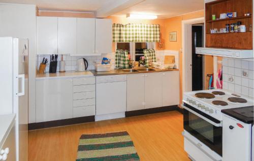a kitchen with white cabinets and a stove top oven at Three-Bedroom Holiday Home Brösarp With A Fireplace 05 in Brösarp