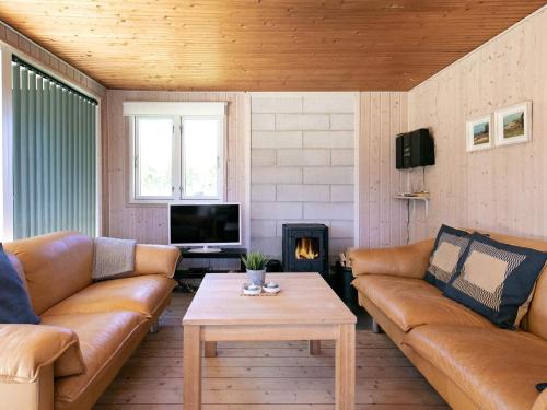 a living room with leather couches and a coffee table at 4 person holiday home in Hjørring-By Traum in Lønstrup