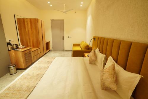 a bedroom with a large bed and a couch at Varay Eco Hotel in Ujjain