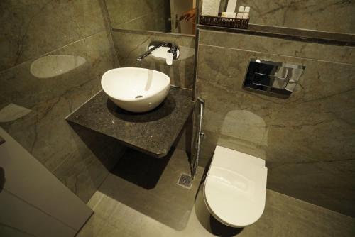 a bathroom with a sink and a toilet at Varay Eco Hotel in Ujjain