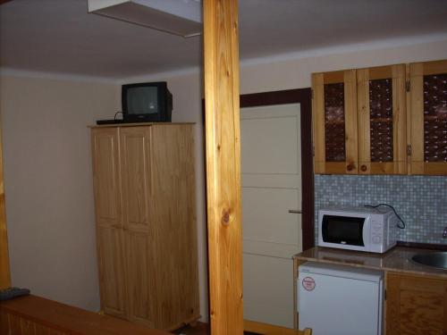a kitchen with a microwave on a counter and a door at Penzion U Račáku in Frymburk