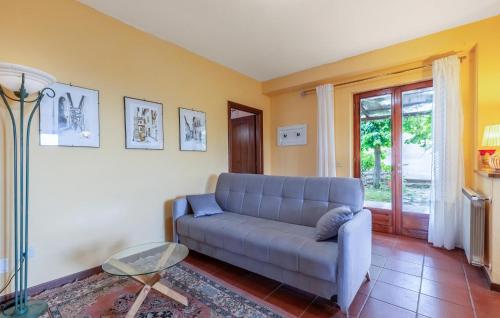 a living room with a blue couch and a window at Gorgeous Home In S Maria In Tiberina in Monte Santa Maria Tiberina