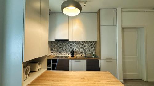 a kitchen with white cabinets and a light fixture at Timisoara Prime Residence - powered by NEO - private parking in Timişoara
