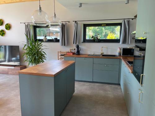 a kitchen with blue cabinets and a wooden counter top at Casa Guzinni in Písečná