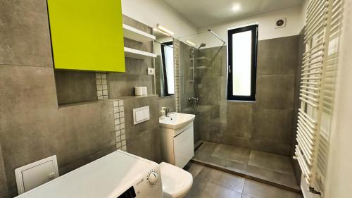 a bathroom with a toilet and a sink and a tub at Timisoara Prime Residence - powered by NEO - private parking in Timişoara