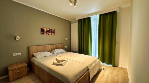 a bedroom with a bed and a window with green curtains at Timisoara Prime Residence - powered by NEO - private parking in Timişoara