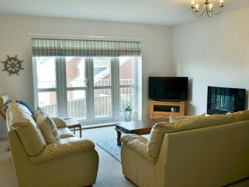 a living room with two couches and a table at Captain Ron's in Beadnell