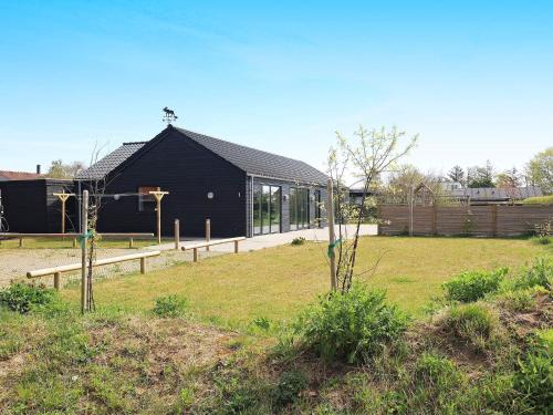a black building with a basketball hoop in a yard at 14 person holiday home in Hadsund in Hadsund