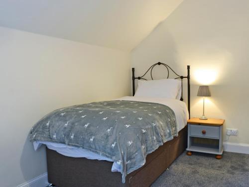a bedroom with a bed and a lamp on a table at Halleaths Home Farm in Lochmaben