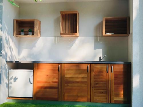 a kitchen with a sink and wooden cabinets at Glamping - domačija Lamperček in Velenje