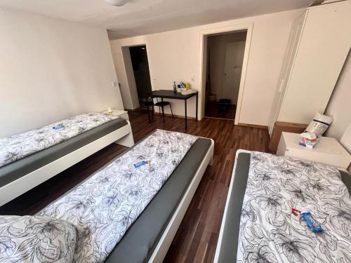 a room with two beds and a table in it at Monteur- und Ferienwohnung Neustadt an der Weinstraße in Neustadt an der Weinstraße