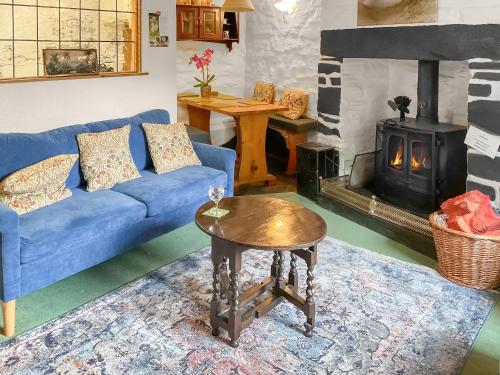 a living room with a blue couch and a wood stove at Bron Elan in Dolwyddelan