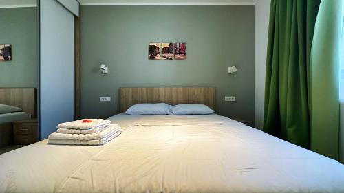 a large bed in a bedroom with green curtains at Timisoara Prime Residence - powered by NEO - private parking in Timişoara
