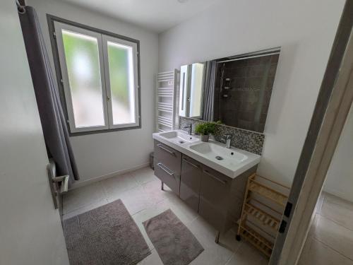 a bathroom with a sink and a mirror and a window at Beautiful Provencal villa in Les Adrets de l'Esterel