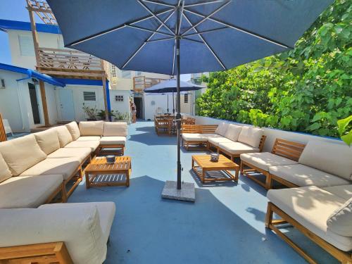 a group of couches and an umbrella on a patio at Kokomo Hotel in Culebra