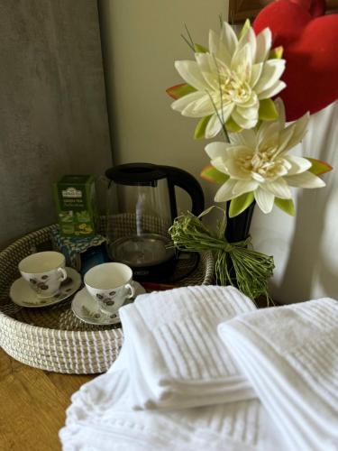 a table with two cups and a vase with flowers at 6 Bedroom 4 bathroom House 14 guests or more in Birmingham, Wolverhampton, Walsall Contractors, Family & Groups in Walsall