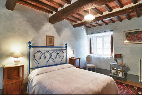 ein Schlafzimmer mit einem blauen Bett in einem Zimmer in der Unterkunft AGRITURISMO Casale Il Caggio in Ciggiano