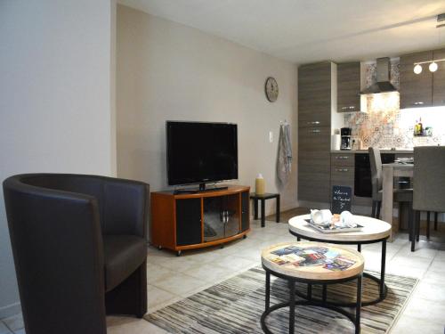 a living room with a flat screen tv and a table at Terrace Apartment, Trois-Ponts in Trois-Ponts