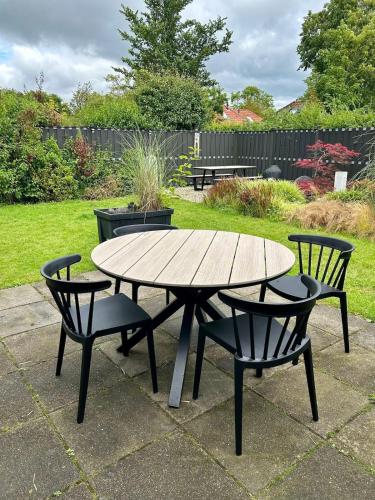 a wooden table and two chairs and a table and chairs at Holiday Home 'Rietvogel' in Herkingen