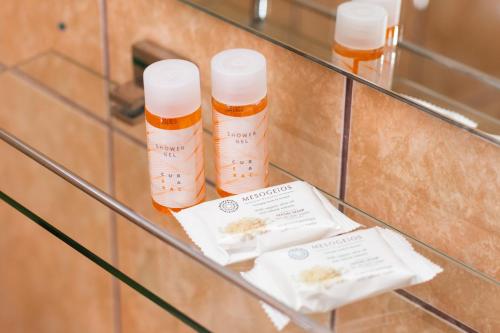 a glass shelf with three bottles of honey at Casa Albă in Baia de Aramă