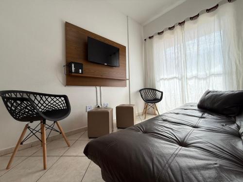 a bedroom with a bed and a flat screen tv at Pé na Areia Praia do Caiçara in Solemar