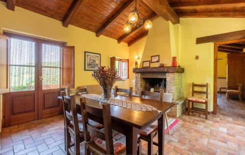 a dining room with a table and a fireplace at Nice Home In Monte Smaria Tiberina in Monte Santa Maria Tiberina