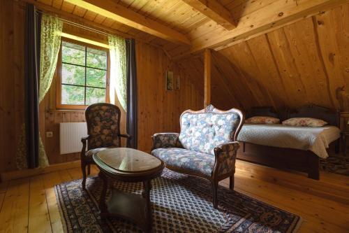 a bedroom with a bed and a chair and a table at Kaimo sodyba Senas rublis in Pesčiai