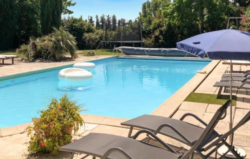an empty swimming pool with chairs and an umbrella at Beautiful Home In Loriol-Sur-Drôme in Loriol-sur-Drôme