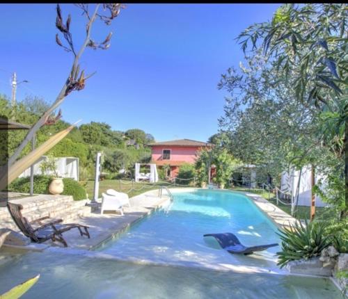 una piscina con tumbonas y una piscina en La Casa Fra gli Ulivi luxury apartments with pool near Cinque Terre and Tuscany, en Monte Marcello