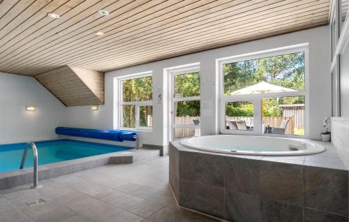 une grande salle de bains avec une baignoire et une piscine dans l'établissement Holiday Home Søren Gades Mark Blåvand Denm, à Blåvand