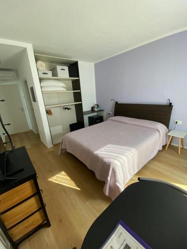 a bedroom with a bed and a dresser and a table at Lotus Garda in Riva del Garda