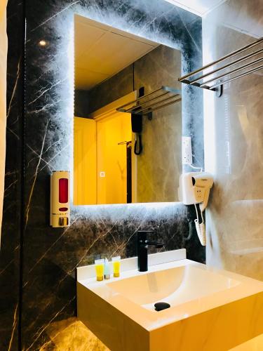 a bathroom with a sink and a mirror at Al Ahrar Hotel in Dubai