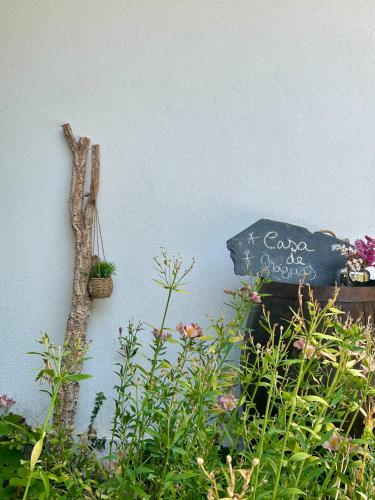 a sign on the side of a wall with plants at Casa de Fráguas in Arouca