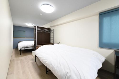 Postel nebo postele na pokoji v ubytování BSx Bell stay 宇宿