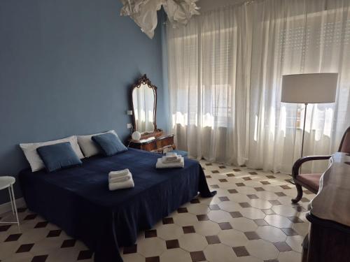 a blue bedroom with a bed with towels on it at Casa Graziella in Capo dʼOrlando