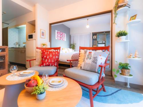 a living room with a table and chairs and a bedroom at Vacation Rental 205- 駐車場無料 in Takamatsu