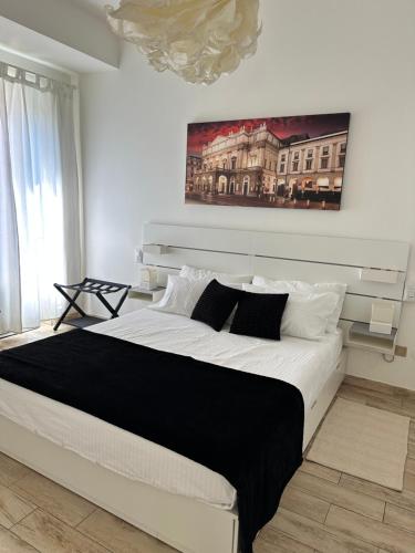 a bedroom with a large white bed with a painting on the wall at Residenza Idra in Segrate