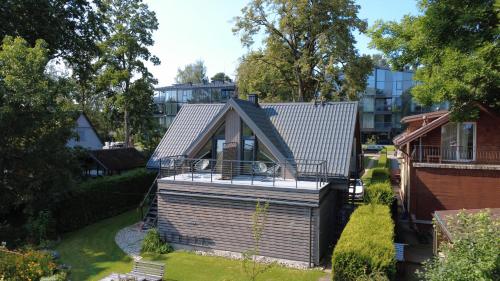 a small house with a deck in a yard at Rytas cozy apartment in the guest house with the terrace and the stunning view to the river side in Birštonas