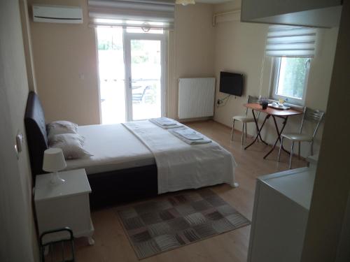 1 dormitorio con 1 cama, mesa y sillas en Karaagac Green Edirne, en Edirne