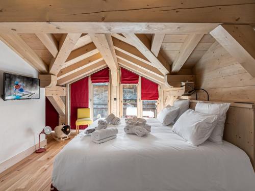 ein großes weißes Bett in einem Zimmer mit Holzdecken in der Unterkunft Chalet spacieux près des pistes avec sauna et WiFi, animaux admis - FR-1-567-69 in Val dʼIsère
