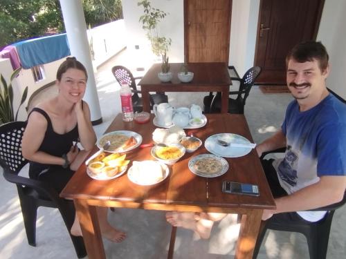 a man and a woman sitting at a table with breakfast at Mirissa Villa Green Pepper in Mirissa