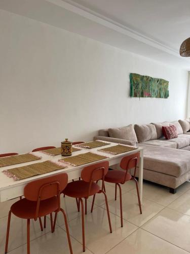 a living room with a table and chairs and a couch at Beach & Pool - Adan Beach in Aourir