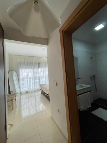a room with a bed and a room with a mirror at Beach & Pool - Adan Beach in Aourir