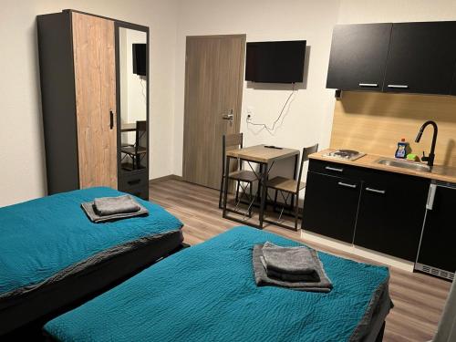 a room with two beds and a kitchen with a sink at HausOase Zimmervermietung Gergert in Schwäbisch Hall
