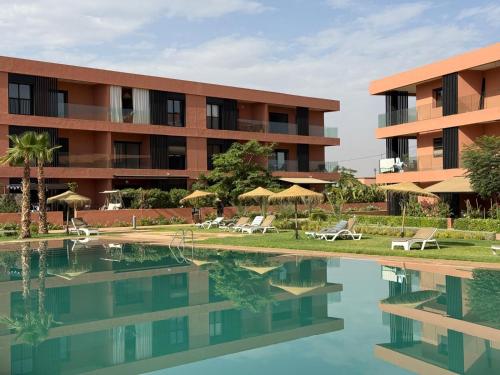 un hotel con piscina frente a un edificio en Amberdi Noria Apartment Marrakech, en Marrakech