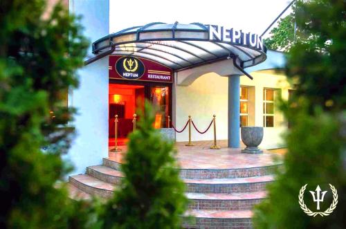 a building with a sign on the front of it at Neptun Ψ Resort in Jastrzębia Góra